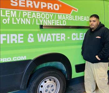 male employee standing in front of a SERVPRO van